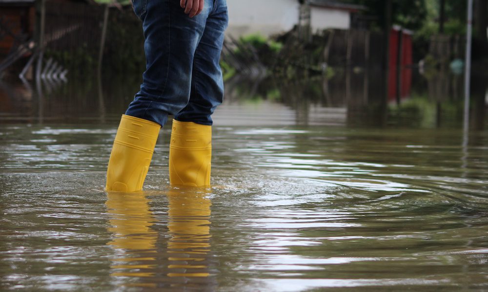 Blog - Person-Standing-In-High-Water-Wearing-Yellow-Rain-Boots-And-Jeans