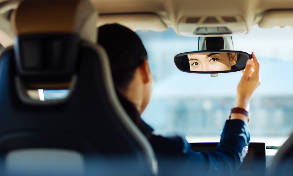 Technology Helps Identify, Reward Safe Drivers - Woman in Car Checking Mirrors and Driving Safely