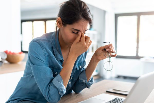 Stressed business woman working from home on laptop looking worried, tired and overwhelmed.