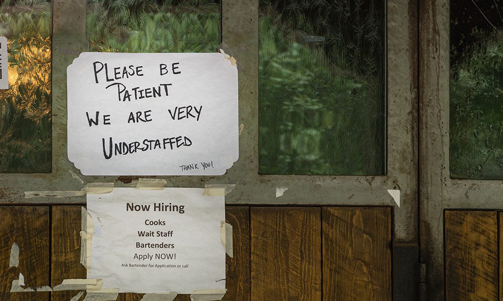Blog - Please Be Patient We are Very Understaffed Sign Outside of Business with a Now Hiring Sign Under it